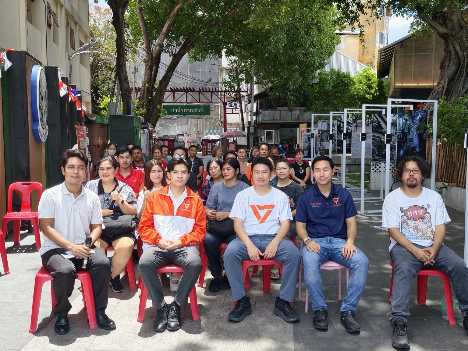 Thanapat and fellow speakers seated with residents at Phanurangsi Pier in Talat Noi