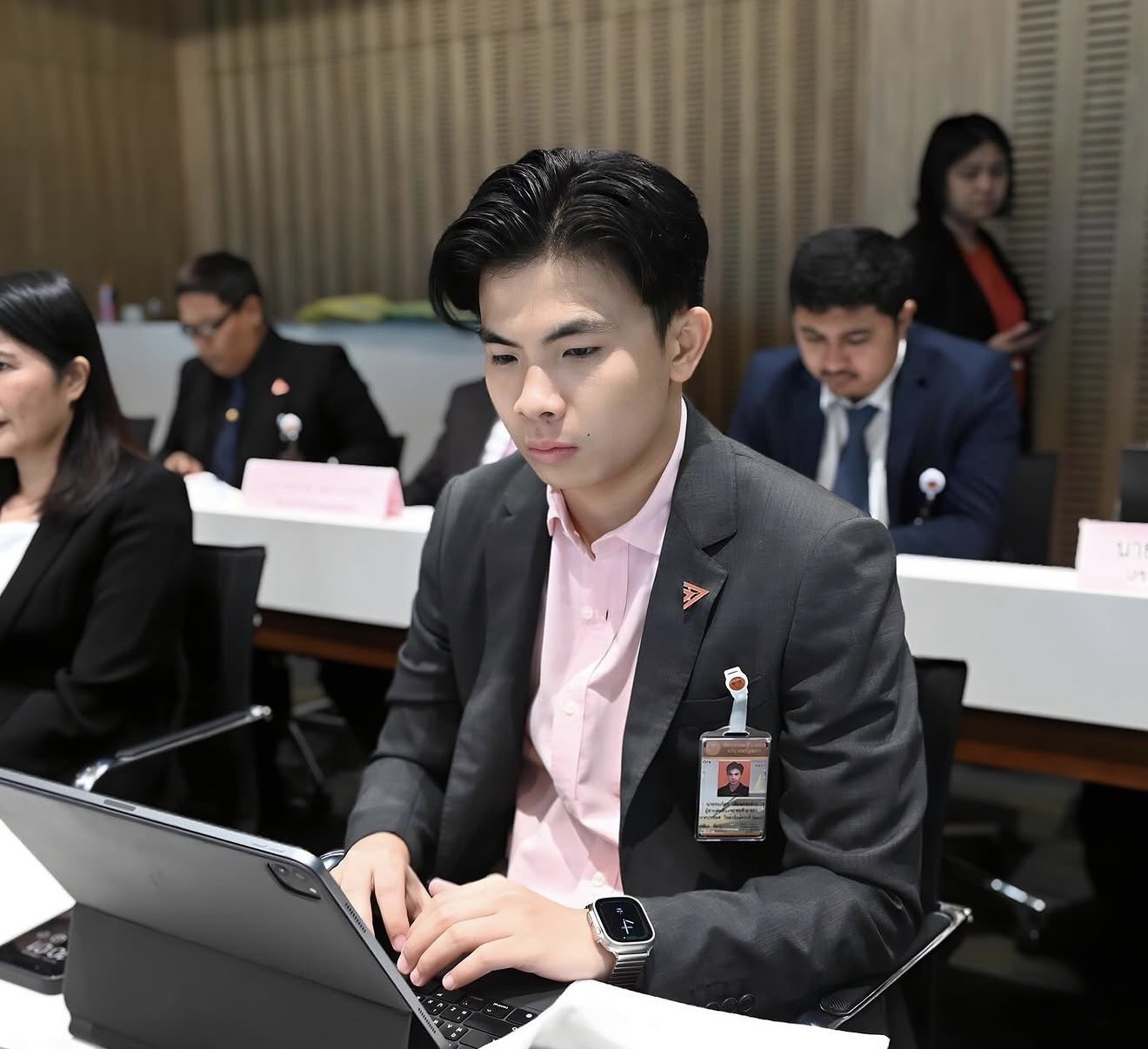 Thanapat works on a tablet during a parliamentary security committee meeting