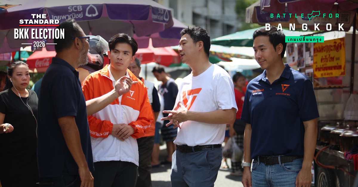 Thanapat and fellow speakers talking with a vendor in Talat Noi, the THE STANDARD article cover
